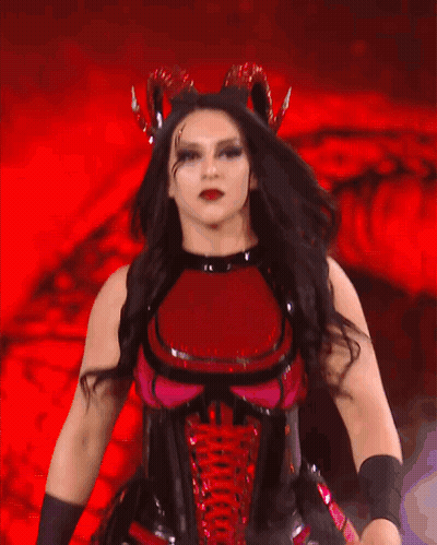A Woman In A Red And Black Costume Is Dancing GIF