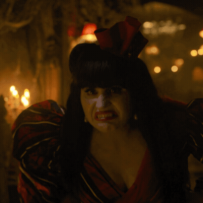 A Woman In A Red And Black Dress With A Red Bow In Her Hair GIF