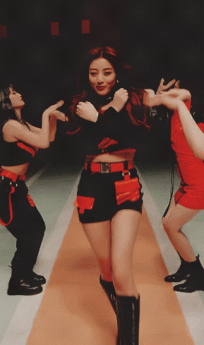 A Woman In A Red And Black Outfit Is Dancing GIF