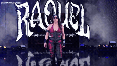 A Woman In A Red And Black Outfit Is Walking In Front Of A Sign That Says ' Raquel ' GIF