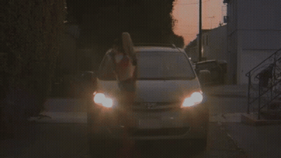 A Woman In A Red And White Crop Top Is Getting Out Of A Car . GIF