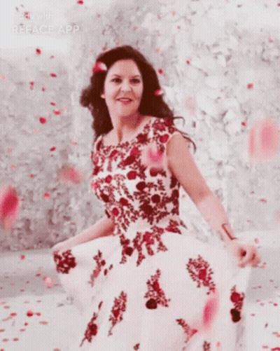 A Woman In A Red And White Dress Is Standing In Front Of A Wall GIF