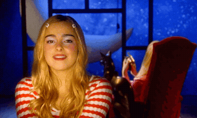 A Woman In A Red And White Striped Shirt Is Sitting In A Chair GIF