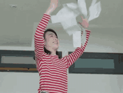 A Woman In A Red And White Striped Shirt Is Throwing Papers Into The Air GIF