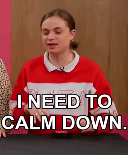 A Woman In A Red And White Sweater Is Sitting At A Table . GIF