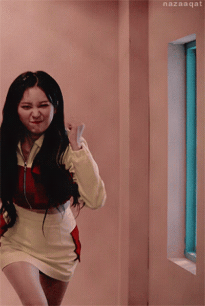 A Woman In A Red And Yellow Outfit Is Running In A Hallway Next To A Window With Nazaaqat Written On The Bottom GIF