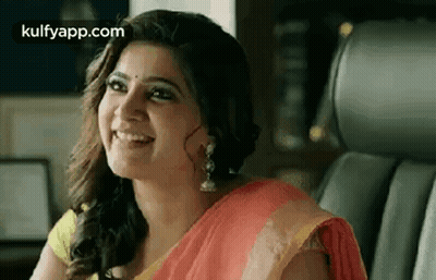 A Woman In A Red And Yellow Saree Is Smiling While Sitting In A Car . GIF