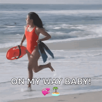 A Woman In A Red Bathing Suit Is Running On The Beach With The Words On My Way Baby Below Her GIF