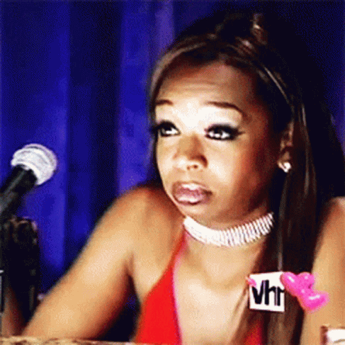A Woman In A Red Bikini Is Sitting In Front Of A Microphone And Making A Face . GIF