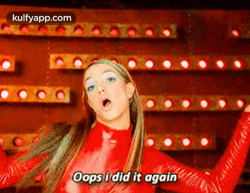 A Woman In A Red Bodysuit Is Dancing In Front Of A Wall Of Lights . GIF
