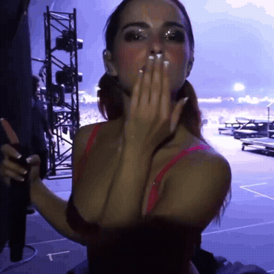 A Woman In A Red Bra Is Blowing A Kiss With A Purple Background GIF