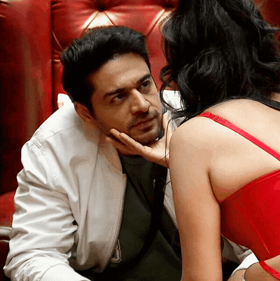 A Woman In A Red Bra Touches The Face Of A Man GIF