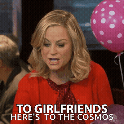 A Woman In A Red Cardigan Says To Girlfriends Here 'S To The Cosmos GIF