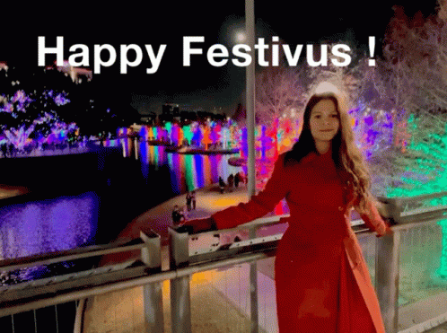 A Woman In A Red Coat Leaning On A Railing With The Words Happy Festivus Written Above Her GIF
