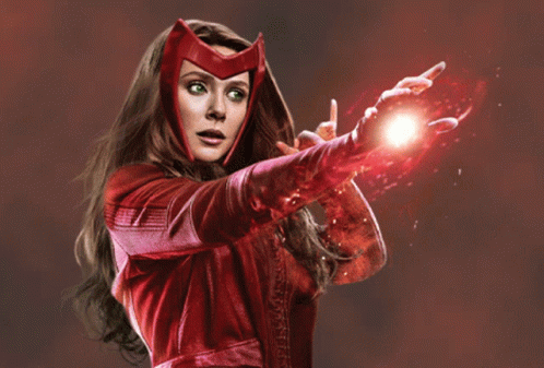 A Woman In A Red Costume Is Holding A Red Object In Her Hand GIF