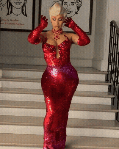 A Woman In A Red Dress And Gloves Stands On Stairs GIF