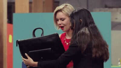 A Woman In A Red Dress Holds A Black Purse With The Letter O On It GIF