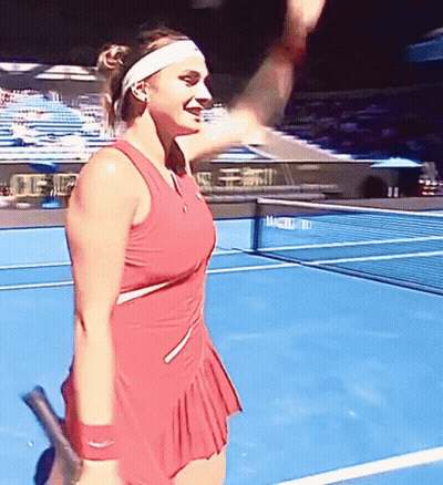 A Woman In A Red Dress Holds A Tennis Racquet On A Tennis Court GIF