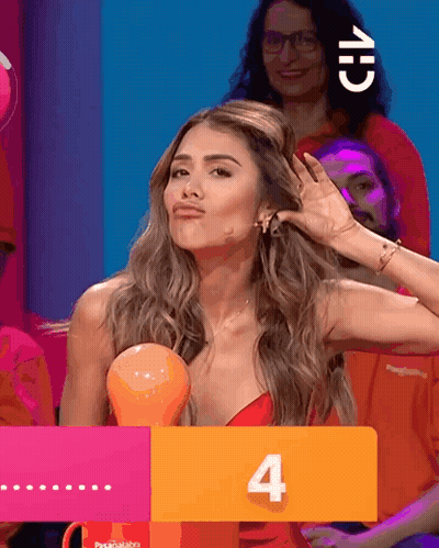 A Woman In A Red Dress Holds Her Hand To Her Ear Behind A Sign That Says 4 GIF
