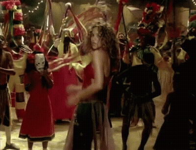 A Woman In A Red Dress Is Dancing In Front Of A Crowd GIF