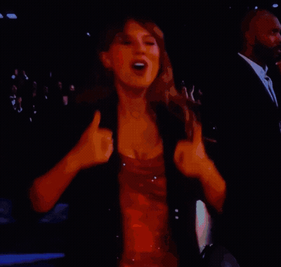 A Woman In A Red Dress Is Dancing On A Stage In Front Of A Crowd GIF