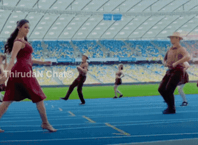 A Woman In A Red Dress Is Dancing On A Track In A Stadium With Thiruda N Chat Written In The Corner GIF