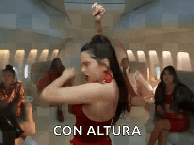 A Woman In A Red Dress Is Dancing On An Airplane With The Words Con Altura Written On The Bottom . GIF