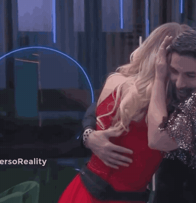 A Woman In A Red Dress Is Dancing With A Man In A Suit And Tie . GIF