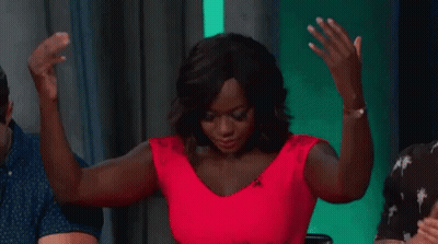 A Woman In A Red Dress Is Dancing With Her Arms In The Air . GIF