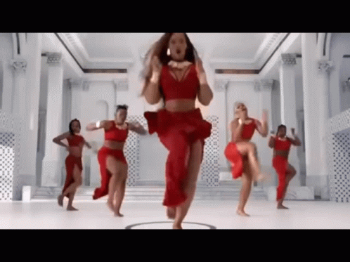A Woman In A Red Dress Is Dancing With Other Women GIF