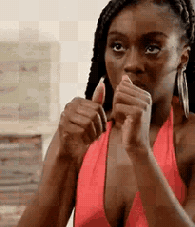 A Woman In A Red Dress Is Giving A Thumbs Up . GIF