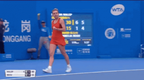 A Woman In A Red Dress Is Holding A Tennis Racket On A Tennis Court GIF