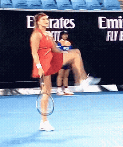 A Woman In A Red Dress Is Holding A Tennis Racquet On A Blue Court GIF