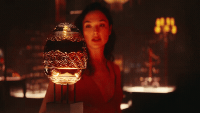 A Woman In A Red Dress Is Holding A Trophy In Her Hands GIF