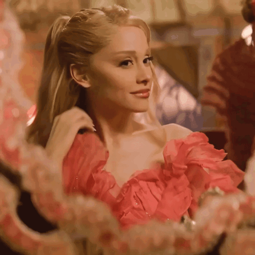 A Woman In A Red Dress Is Looking In A Mirror GIF
