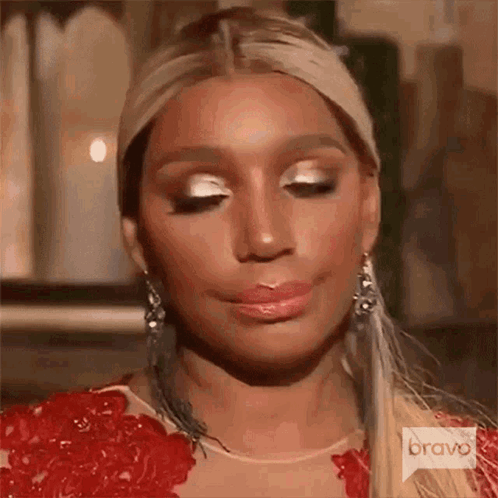 A Woman In A Red Dress Is Making A Funny Face . GIF