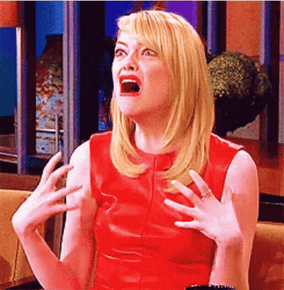 A Woman In A Red Dress Is Making A Surprised Face With Her Mouth Open . GIF