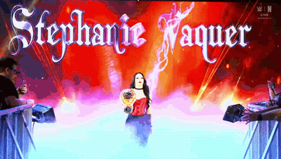 A Woman In A Red Dress Is On A Stage With The Name Stephanie Vaquer GIF
