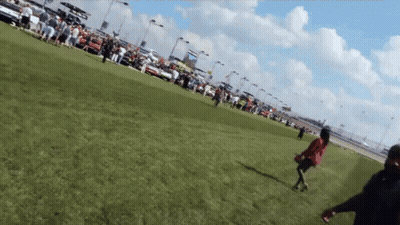 A Woman In A Red Dress Is Running In A Field GIF
