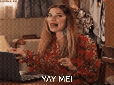 A Woman In A Red Dress Is Sitting At A Table With A Laptop And Making A Funny Face . GIF