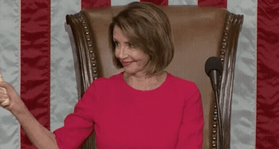 A Woman In A Red Dress Is Sitting In A Chair Holding A Wooden Hammer . GIF