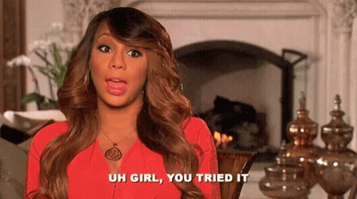 A Woman In A Red Dress Is Sitting In Front Of A Fireplace And Talking . GIF
