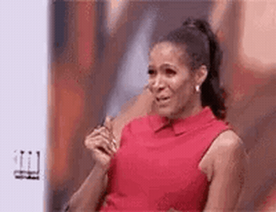 A Woman In A Red Dress Is Sitting On A Couch And Crying . GIF