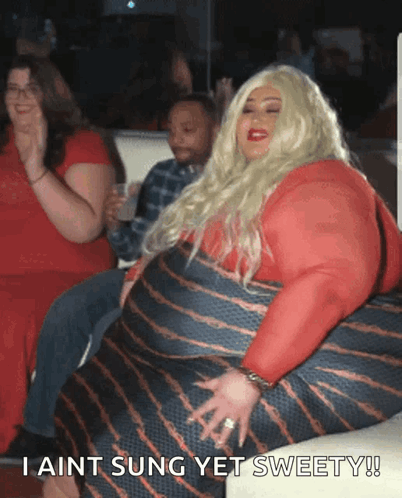 A Woman In A Red Dress Is Sitting On A Couch And Says " I Ain T Sung Yet Sweety " GIF