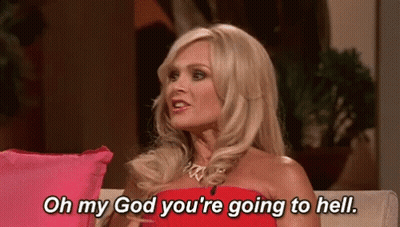 A Woman In A Red Dress Is Sitting On A Couch And Talking To Someone . GIF