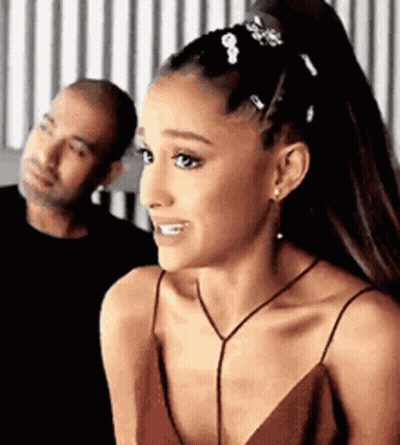 A Woman In A Red Dress Is Smiling While Standing Next To A Man . GIF