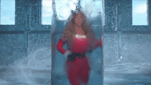 Woman In Red Dress Standing In Glass Container GIF