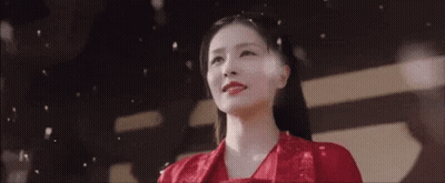 A Woman In A Red Dress Is Standing In Front Of A Black And White Background . GIF