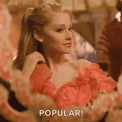 A Woman In A Red Dress Is Standing In Front Of A Mirror And Saying `` Popular '' . GIF