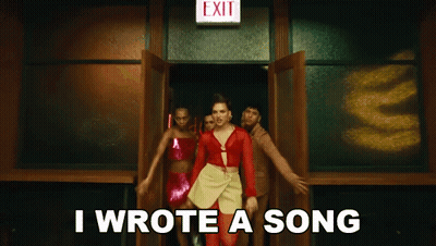 A Woman In A Red Dress Is Standing In Front Of An Exit Sign And Says I Wrote A Song GIF